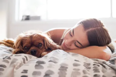 Woman caring for sick dog with chronic kidney disease