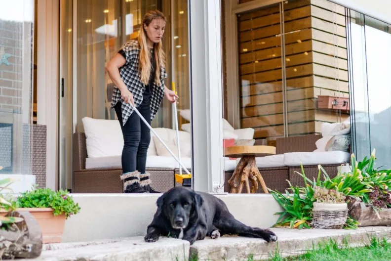 woman cleaning home near dog in yard where to put dog when housecleaners come